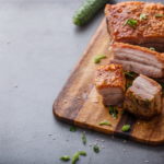 Chinese roasted pork belly on wooden cutting board copy space